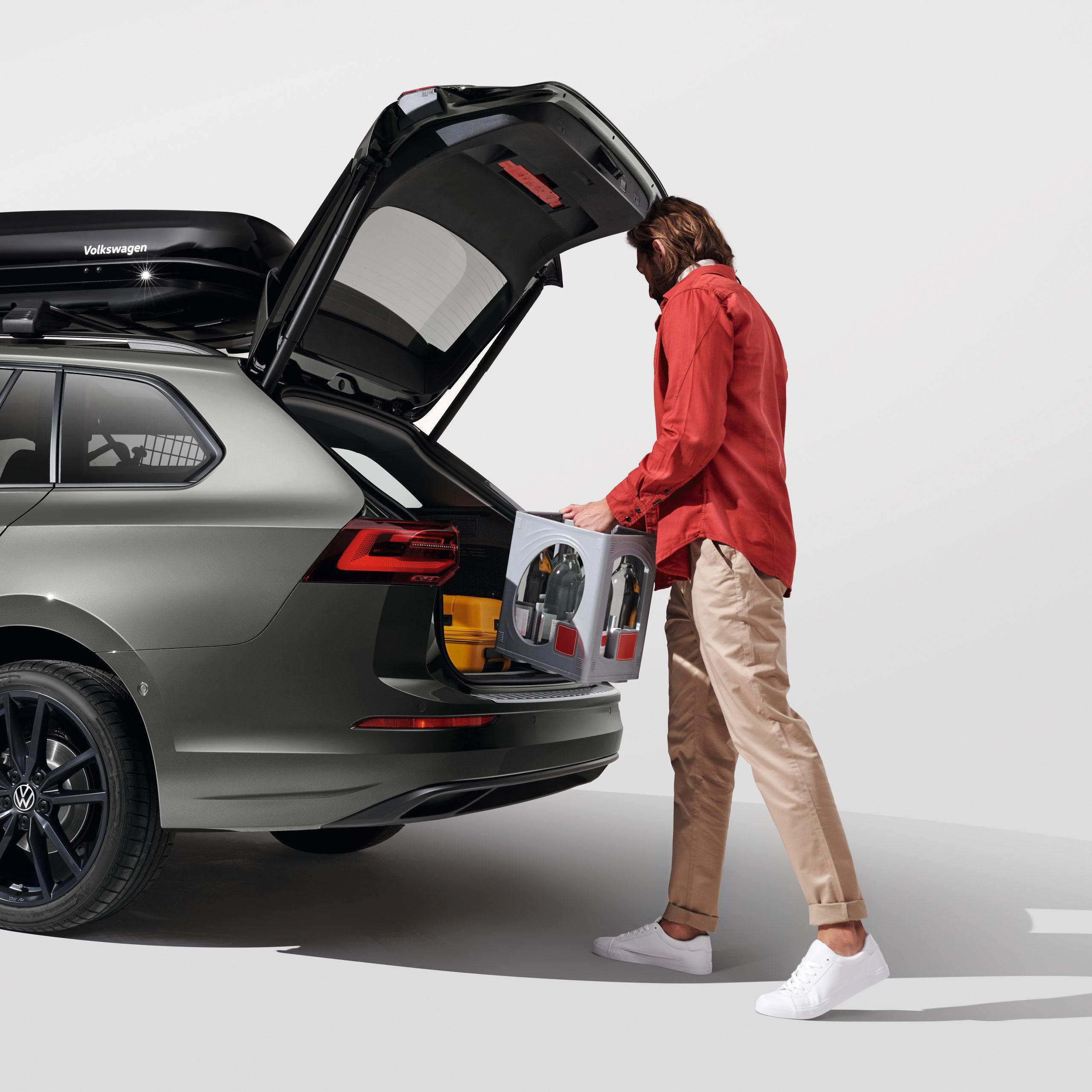 Ein Mann belädt den Kofferraum eines Volkswagen Golf Variant