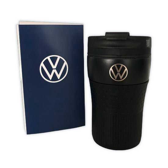 Ein schwarzer Thermobecher mit Volkswagen-Logo neben einer blauen Broschüre mit demselben Logo.