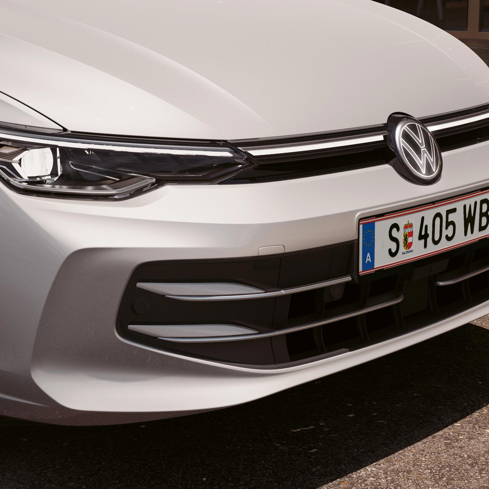 Front eines weißen VW Golf mit Lichtsignatur und beleuchtetem VW-Logo.