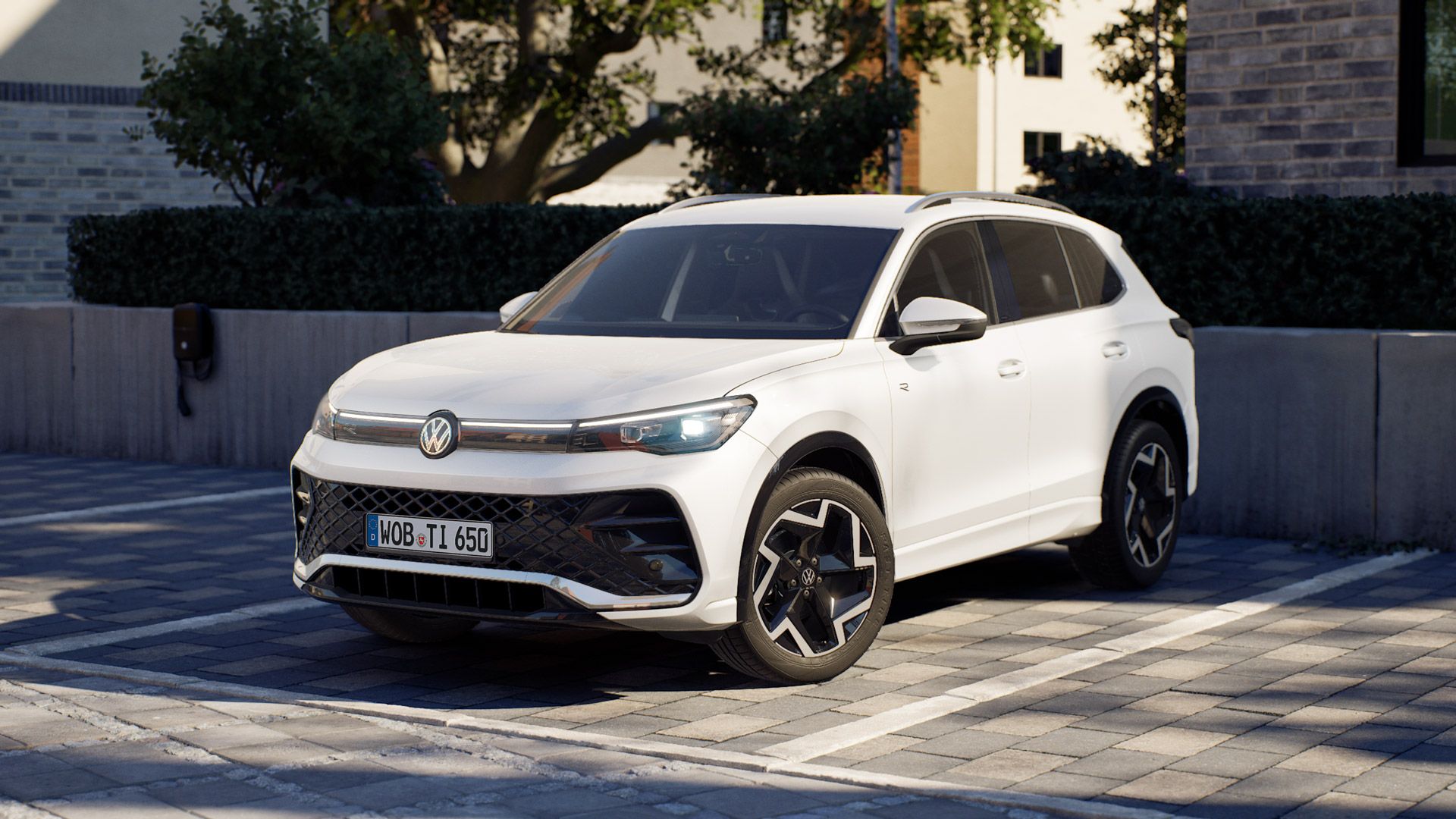 Weißer VW Tiguan, modern und sportlich gestaltet, steht auf einem gepflasterten Parkplatz vor einem Wohn- oder Bürogebäude.  Das Auto hat schwarze Kontraste an Dach und Felgen sowie LED-Scheinwerfer und ein markantes Frontgrill-Design.