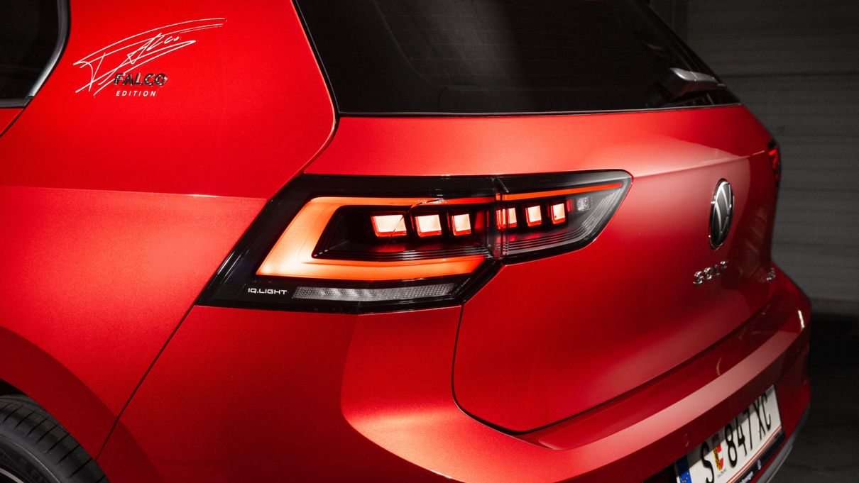 Detailaufnahme des Hecks eines roten VW Golf Falco Edition. Auf der C-Säule ist die Unterschrift von Falco zu sehen.