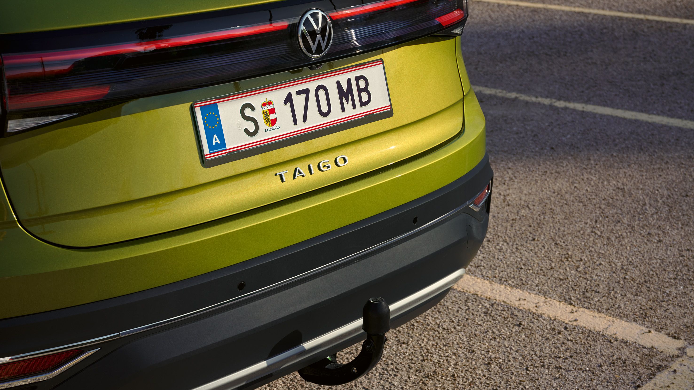 Heckansicht eines grünen VW Taigo mit Anhängerkupplung