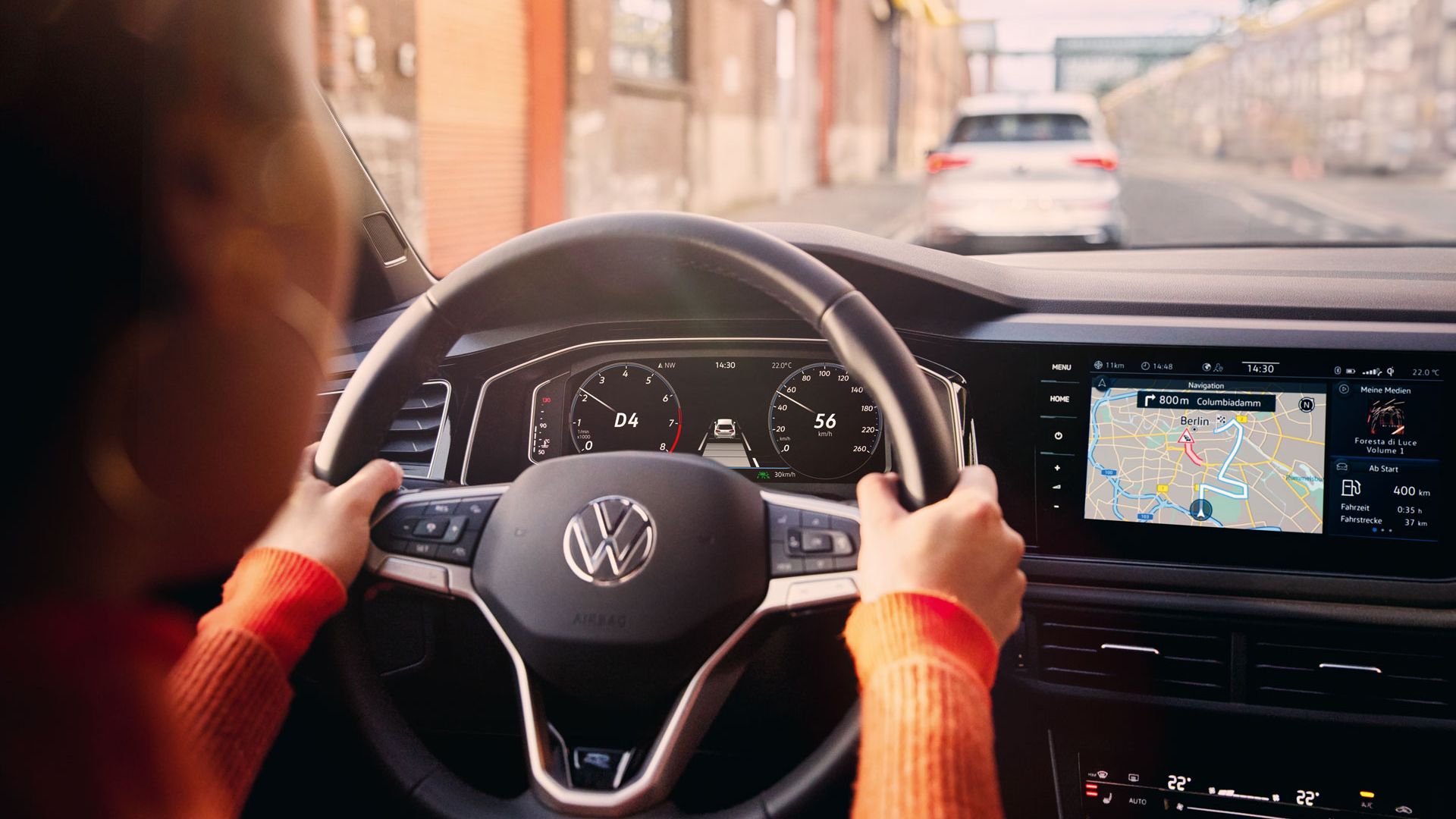 Eine Frau fährt einen VW Polo mit aktiver Navigation auf dem Display des Infotainment-Systems.
