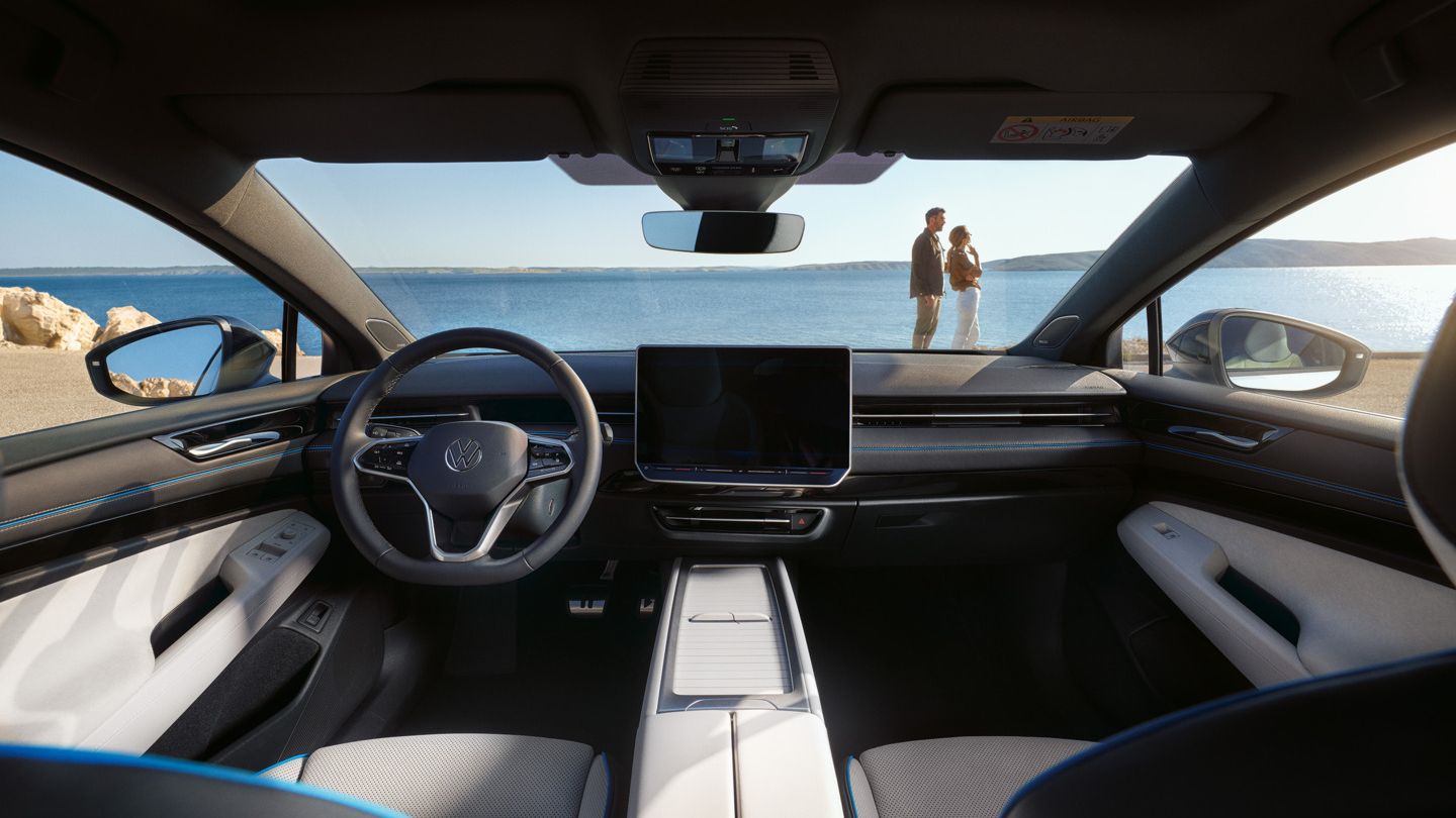 Interieur des ID.7 mit Multifunktionslenkrad, blauen Ziernähten und Infotainmentsystem. 