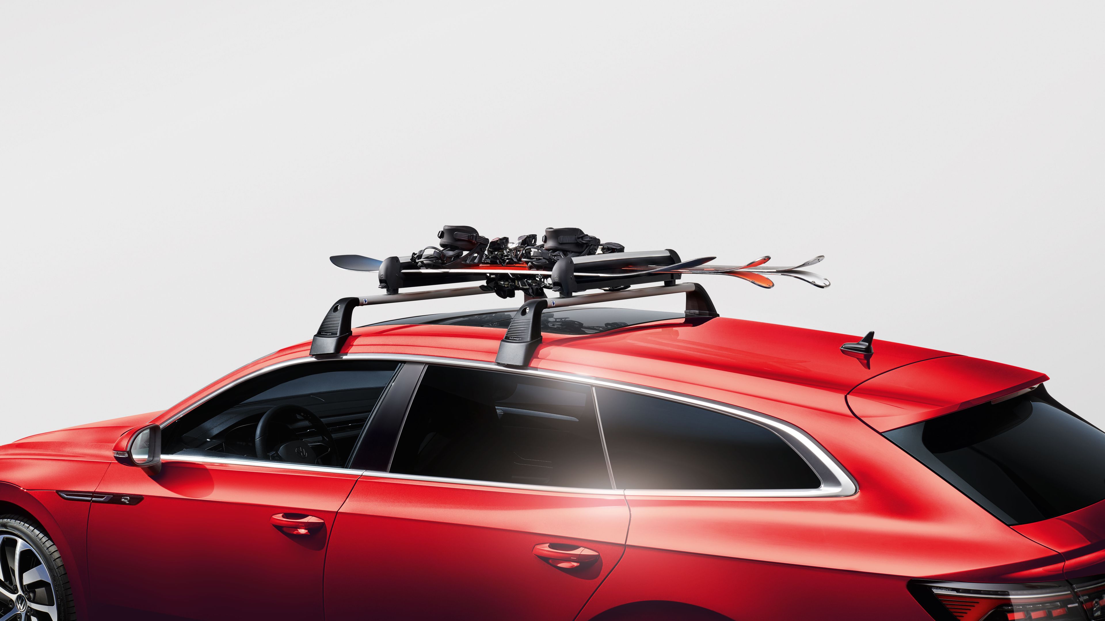 Volkswagen Ski- und Snowboardhalter auf dem Dach eines roten Volkswagen.