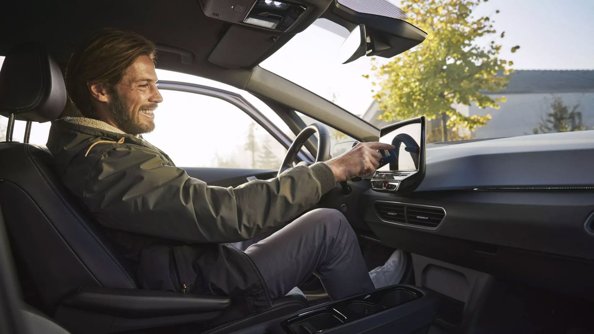 Ein Mann sitzt in einem ID. Modell und nutzt das Infotainment System