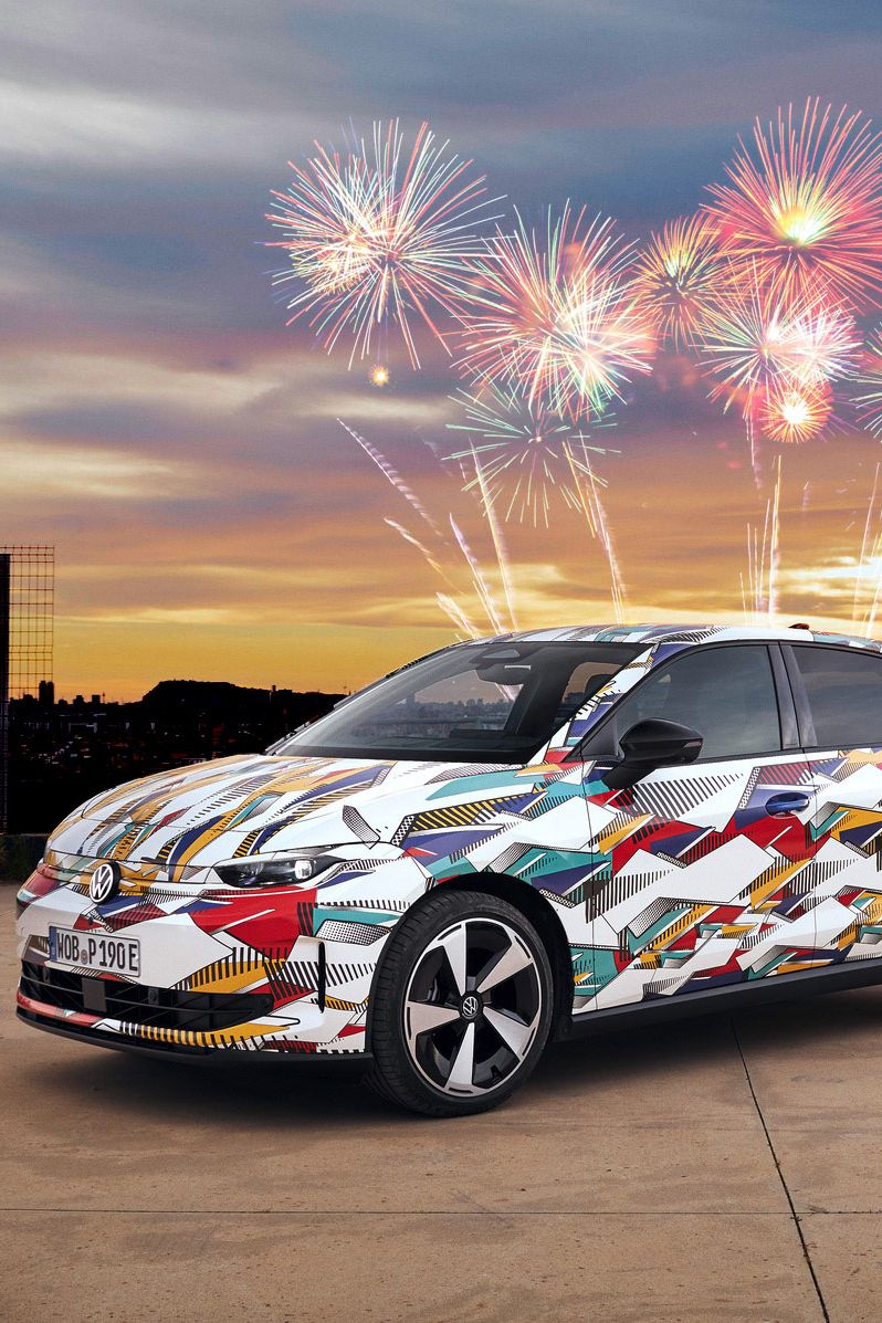 Ein bunter ID. Polo steht draußen vor einem Gebäude, während bunte Feuerwerkskörper den Himmel im Hintergrund erleuchten.