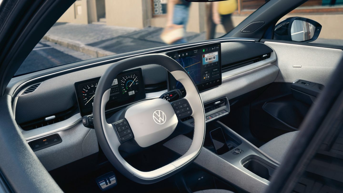 Blick durch die offene Fahrertür auf das Cockpit des VW ID. Polo Style, der am Straßenrand parkt.