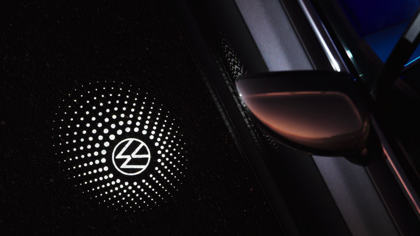 Umfeldbeleuchtung projiziert neben den vorderen Türen des VW Touareg das Markenlogo auf den Boden.