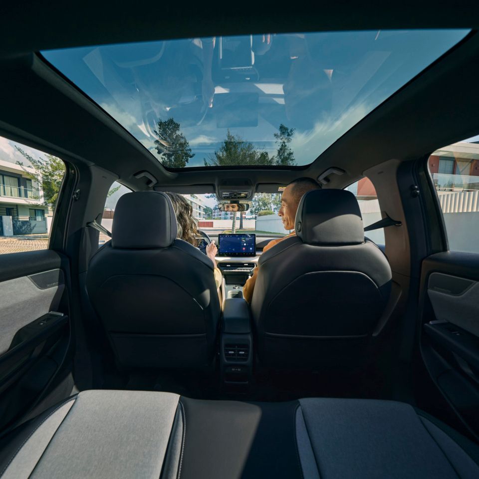 Blick von der Rücksitzbank zu den Frontsitzen eines VW ID. Cross, dort sitzen zwei Personen und unterhalten sich.