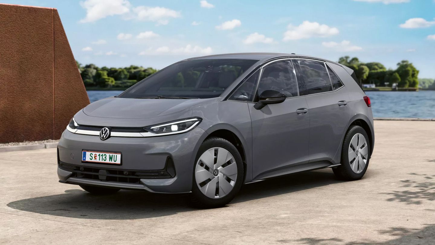 Grauer Volkswagen ID.3 Neo Trend, ein kompakter, fünftüriger Elektro-PKW, steht auf einer Betonfläche im Freien. Im Hintergrund sind Wasser, Bäume und ein blauer Himmel mit wenigen Wolken zu sehen.