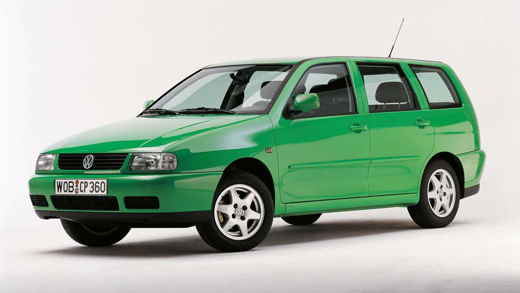 Ein grüner VW Polo 3 Variant von der Seite, vor einem weißen Hintergrund. Das Auto hat vier Türen und silberne Felgen.