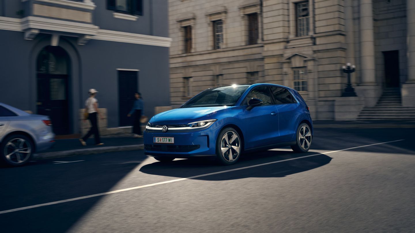Ein blauer VW ID. Polo Style fährt durch eine Stadt.