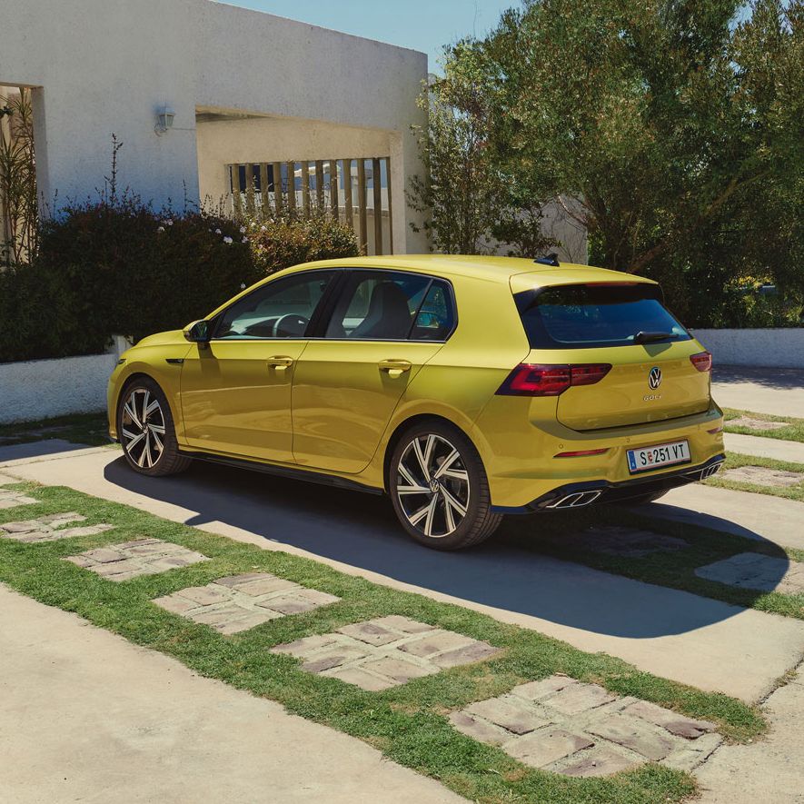 Golf 8 steht auf einem Parkplatz vor einem Haus.