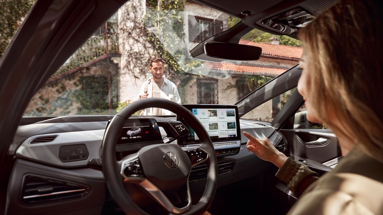 Eine Frau auf dem Fahrersitz bedient den Touchscreen des Infotaimentsystems.