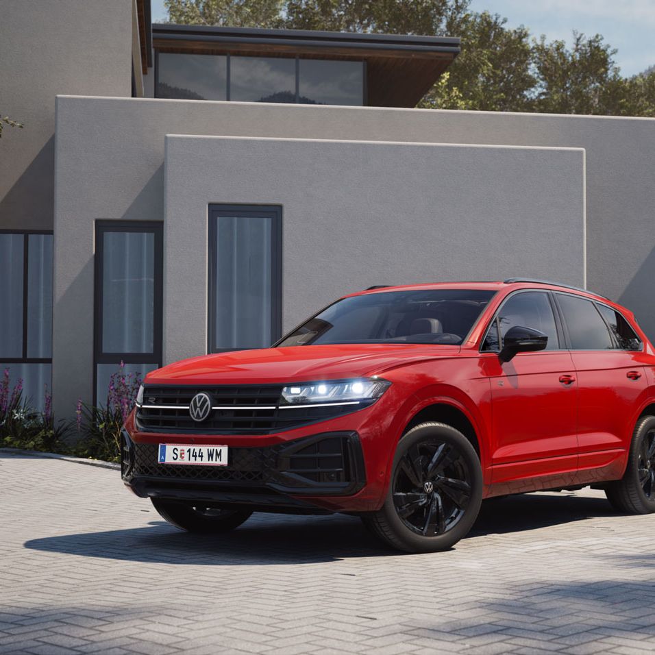 Blick von der Front über die Seite auf einen roten VW Touareg mit R-Line „Exterieur Black Style“-Elementen.