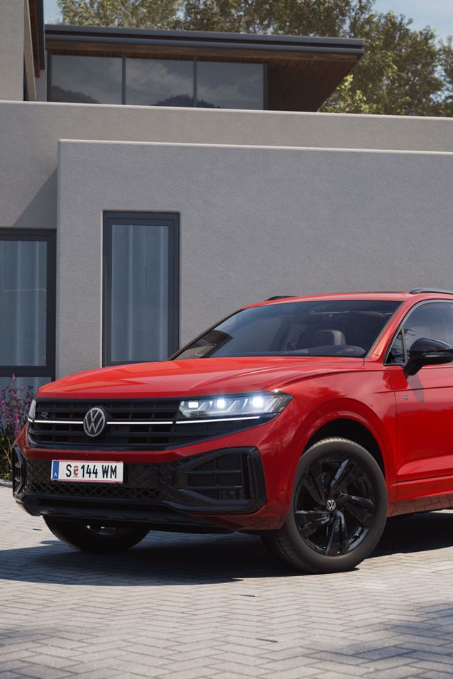 Blick von der Front über die Seite auf einen roten VW Touareg mit R-Line „Exterieur Black Style“-Elementen.