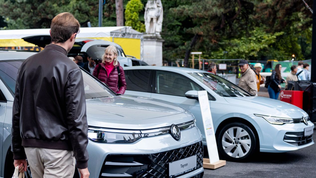 Besucher der Wiener Elektro Tage 2025 erkunden die elektrischen Volkswagenmodelle und eHybride.