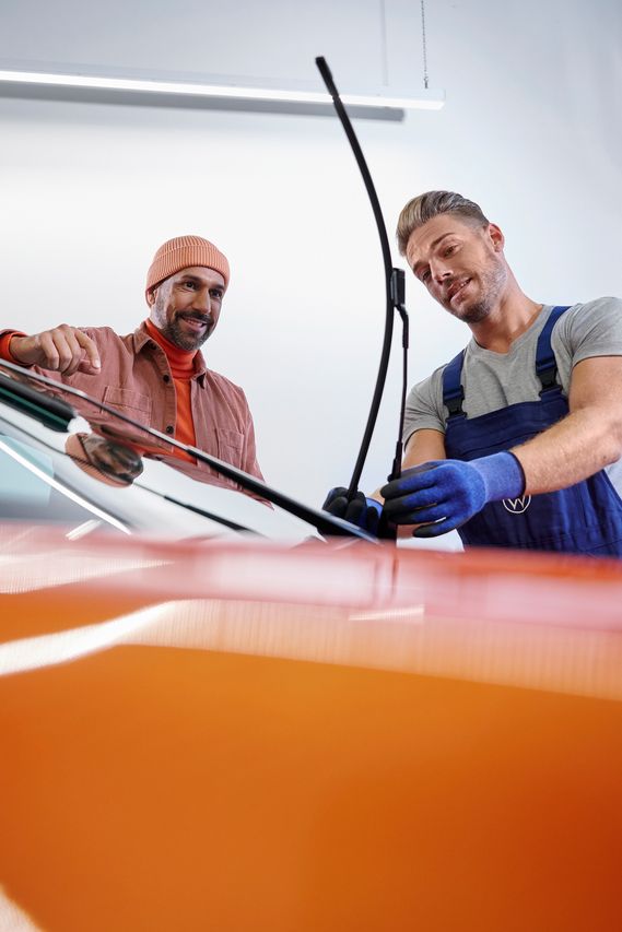 Ein VW Service Techniker wechselt Wischerblätter bei einem Volkswagen