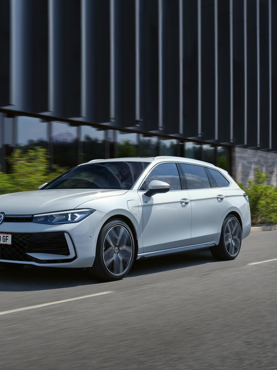 Ein weißer VW Passat R-Line fährt in einer Stadt