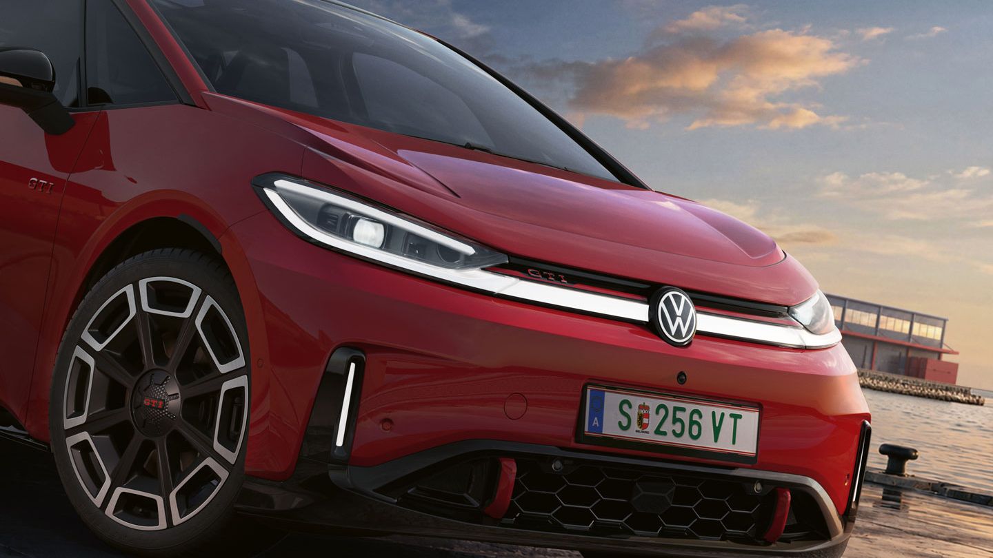 [AI-modified] – Detailansicht der Front eines geparkten roten VW ID.3 GTI mit eingeschalteten Scheinwerfern und beleuchtetem Logo.
