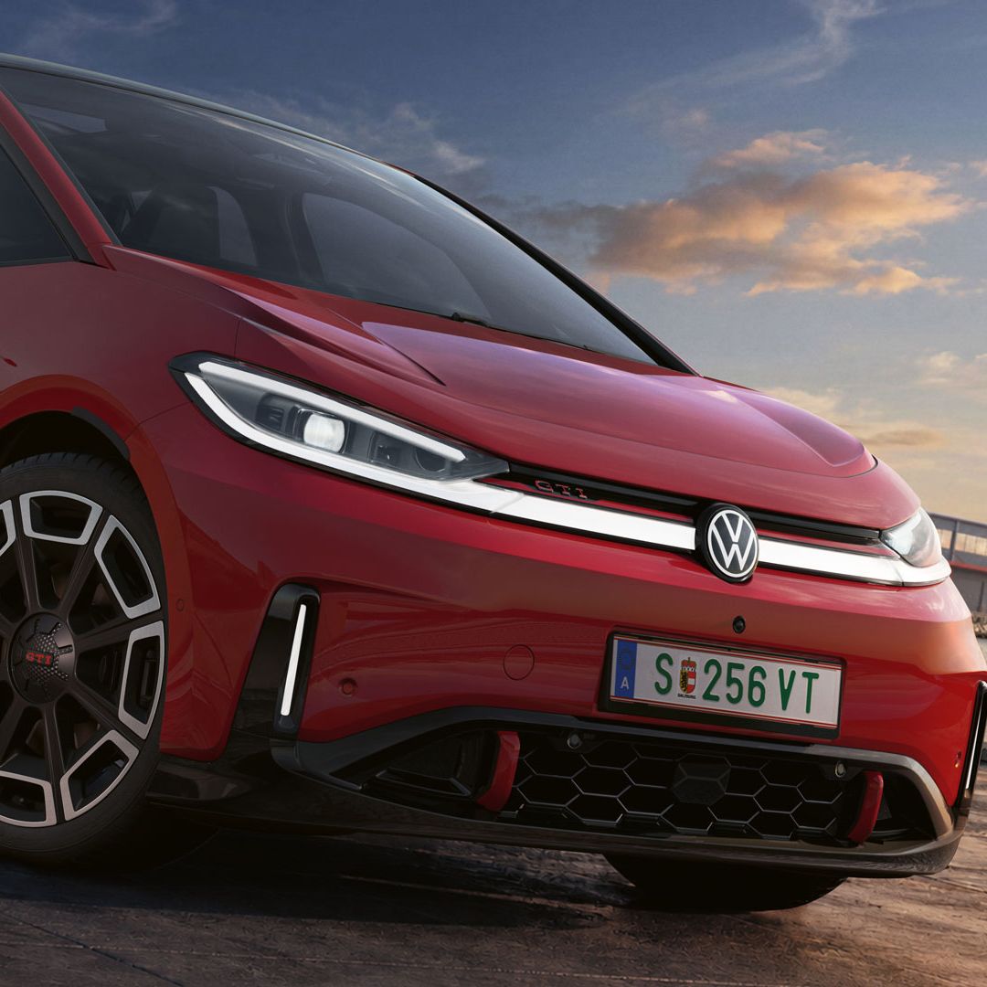 [AI-modified] – Detailansicht der Front eines geparkten roten VW ID.3 GTI mit eingeschalteten Scheinwerfern und beleuchtetem Logo.