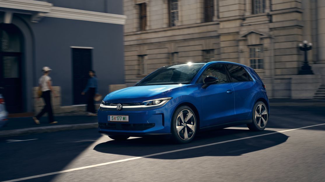 Ein blauer VW ID. Polo Style fährt durch eine Stadt.