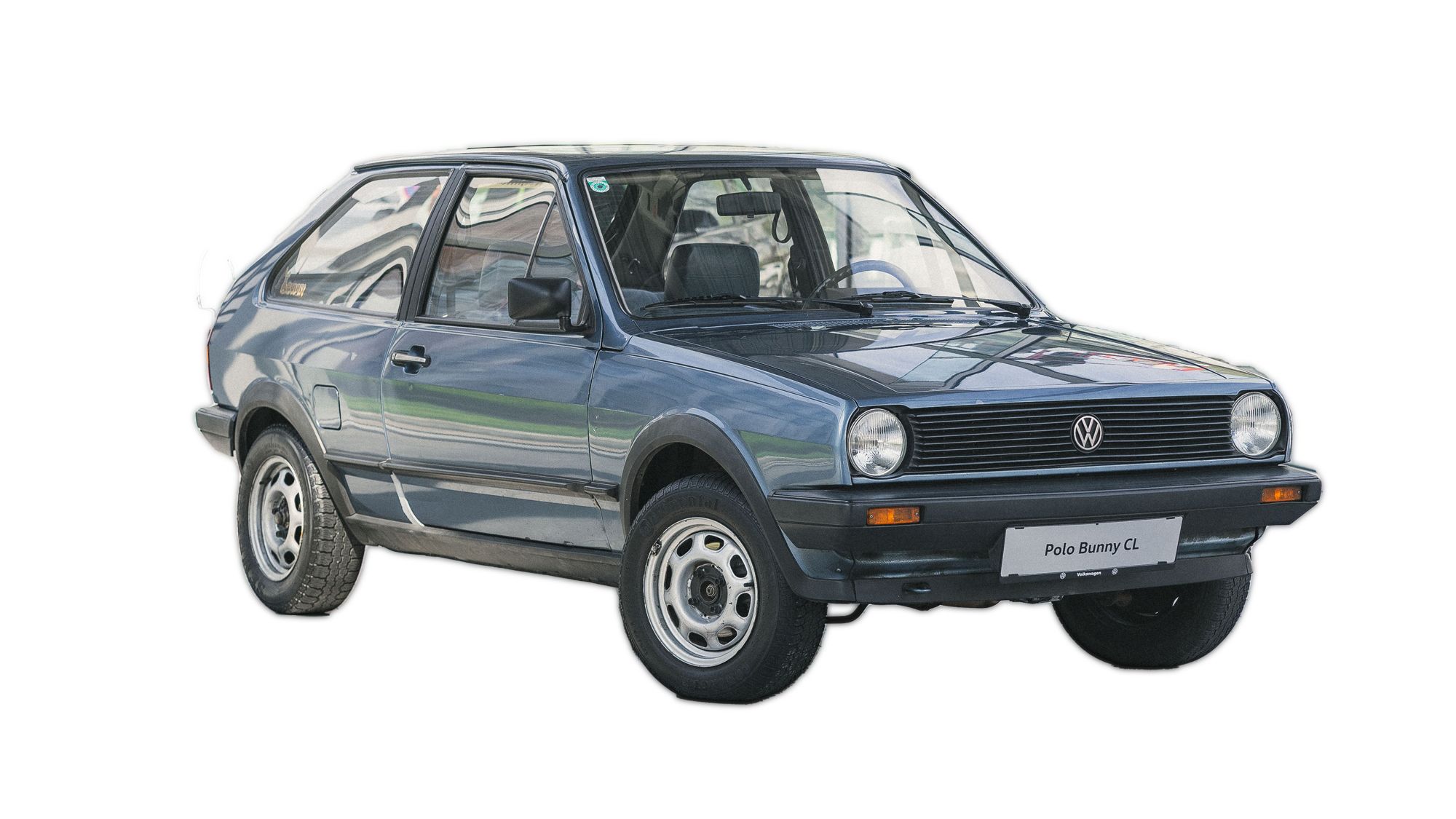 Ein blauer Volkswagen Polo Bunny steht auf einem weißen Hintergrund. Das Auto hat einen rechteckigen Kühlergrill und runde Scheinwerfer. Es ist ein kompakter, zweitüriger Pkw.