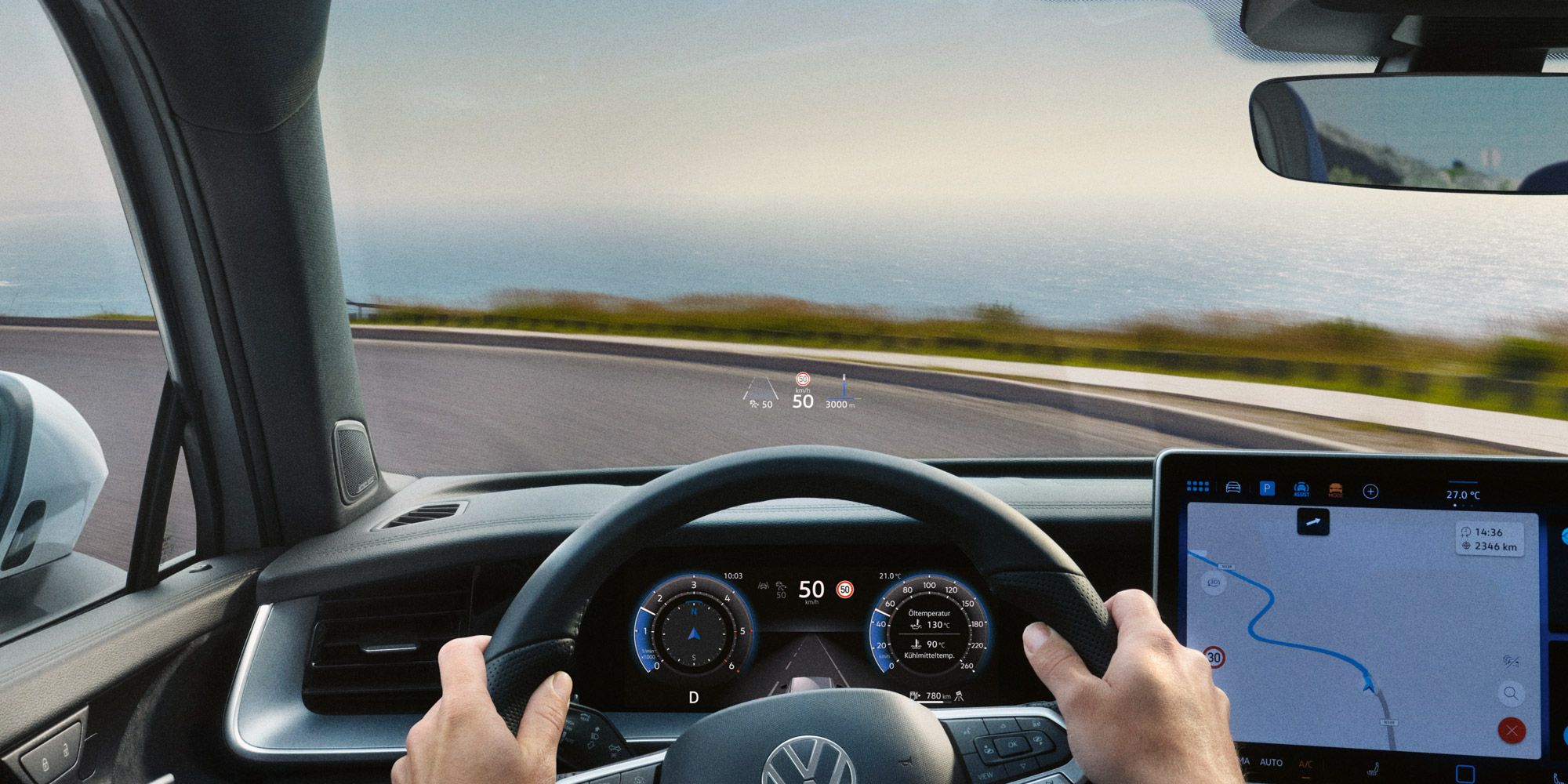 Blick auf das Head-up-Display, Lenkrad und Navigationssystem des VW Tayron während der Fahrt.