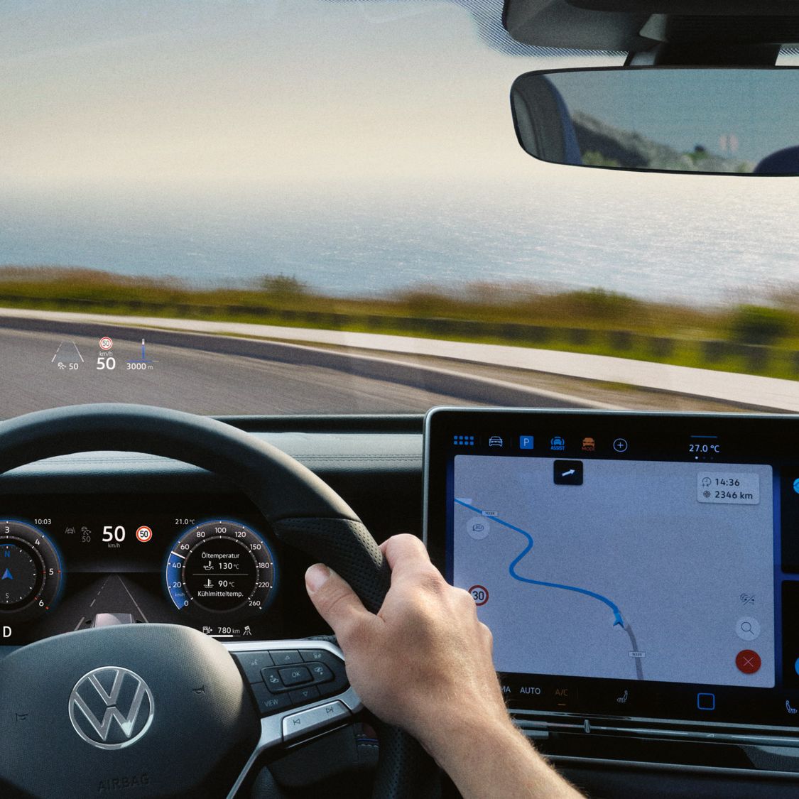 Blick auf das Head-up-Display, Lenkrad und Navigationssystem des VW Tayron während der Fahrt.