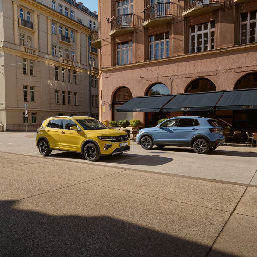 Ein gelber und ein blauer VW T-Cross in einer Stadt geparkt