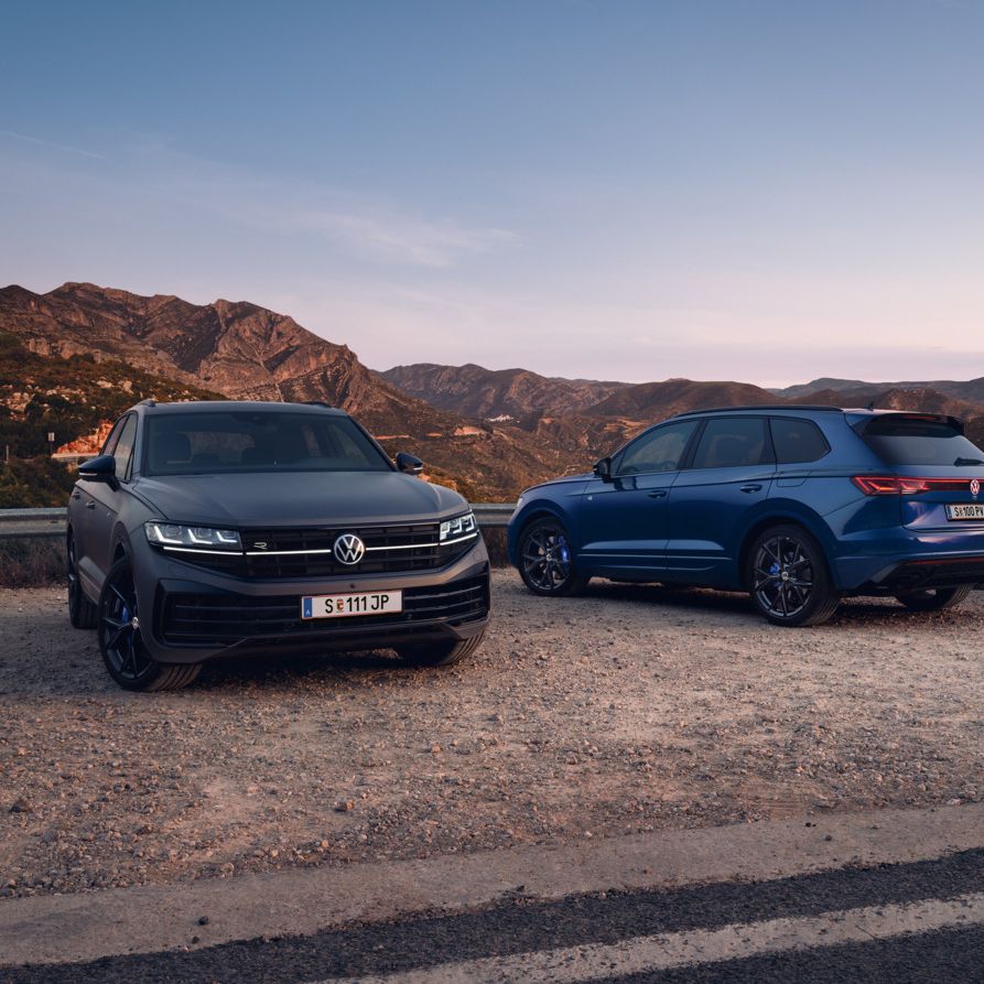 Zwei VW Touareg R in der Vorder- und in der Heckansicht auf einem Parkplatz