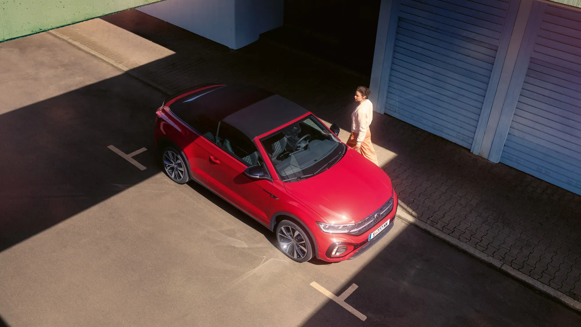 Blick von oben auf ein rotes VW T-Roc Cabriolet mit geschlossenem Verdeck.