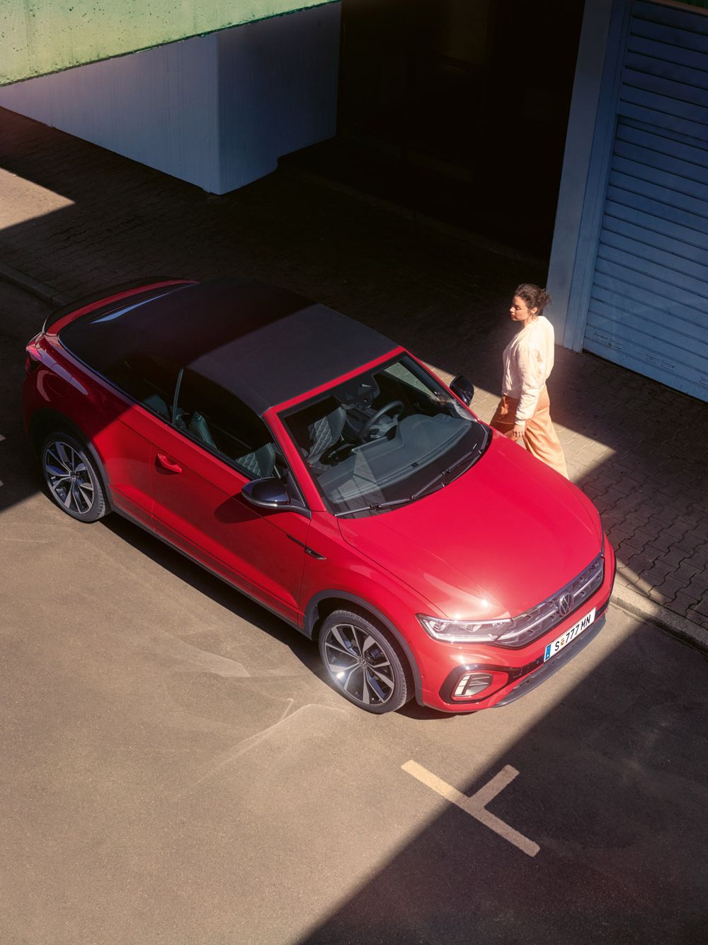 Blick von oben auf ein rotes VW T-Roc Cabriolet mit geschlossenem Verdeck.