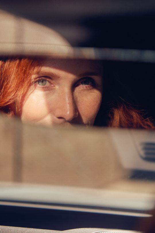 Frau richtet den Spiegel des ID.7 Tourer passend.