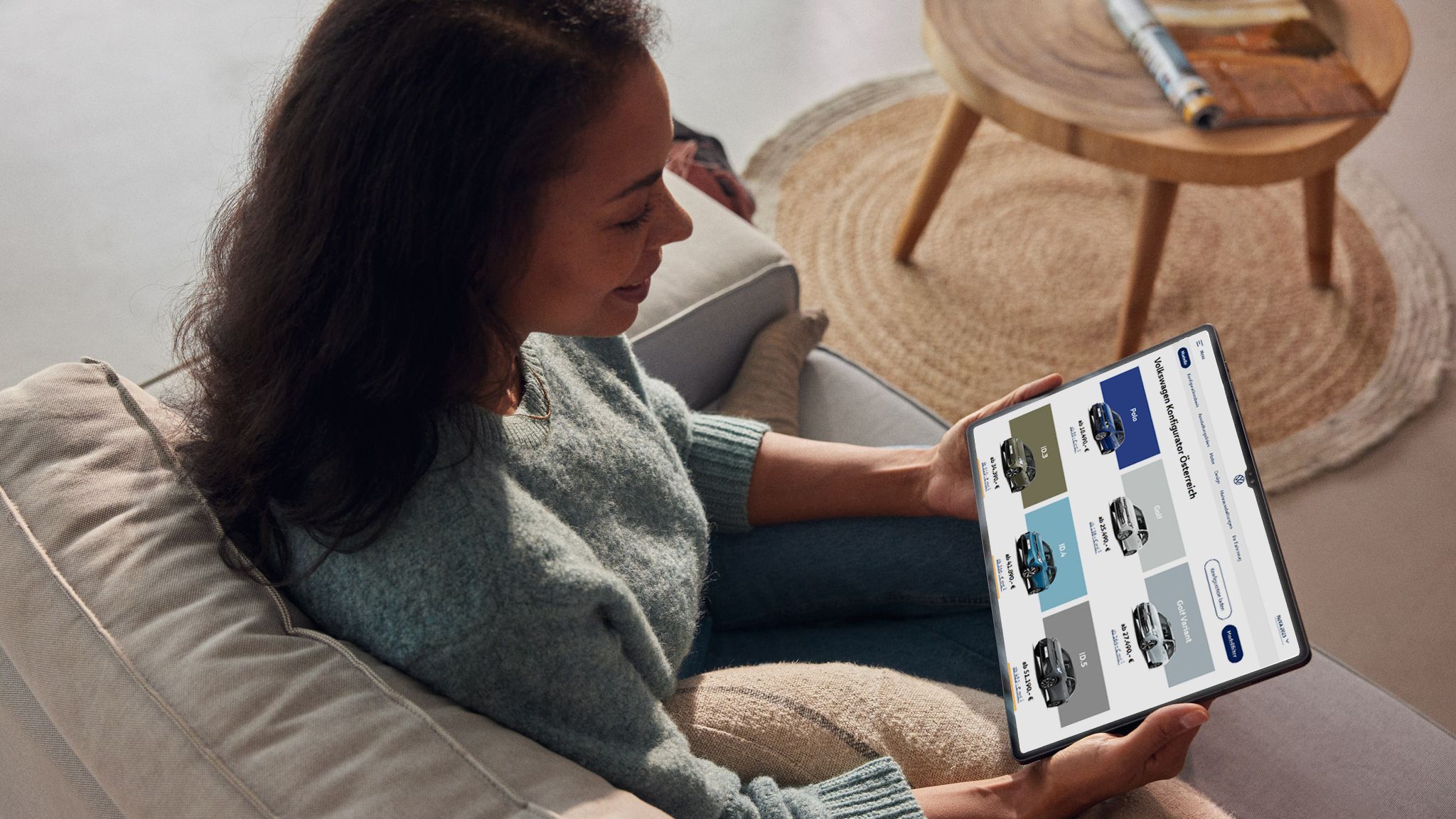 Eine Frau sieht sich die aktuellen VW Modelle auf ihrem Tablet an
