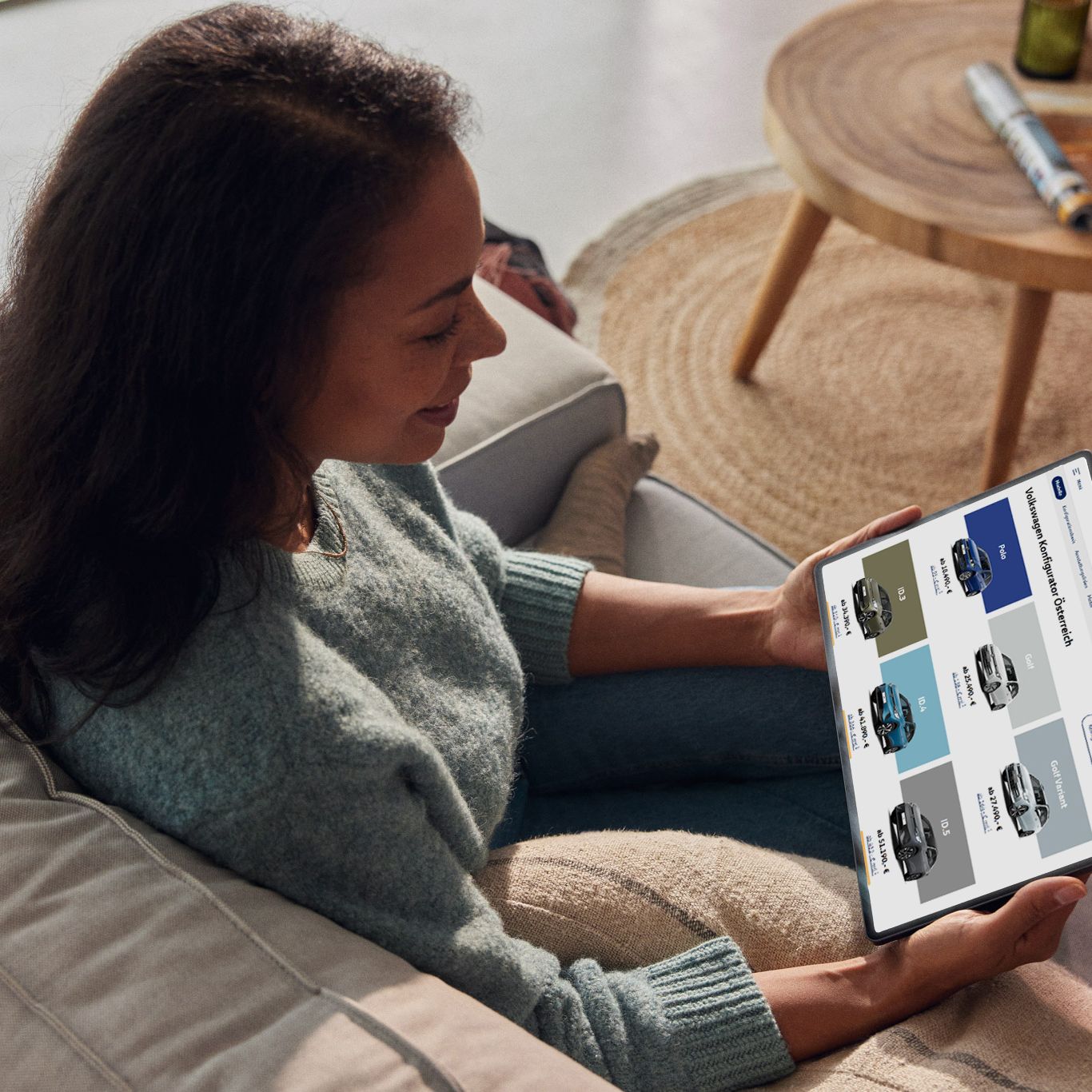 Eine Frau sieht sich die aktuellen VW Modelle auf ihrem Tablet an