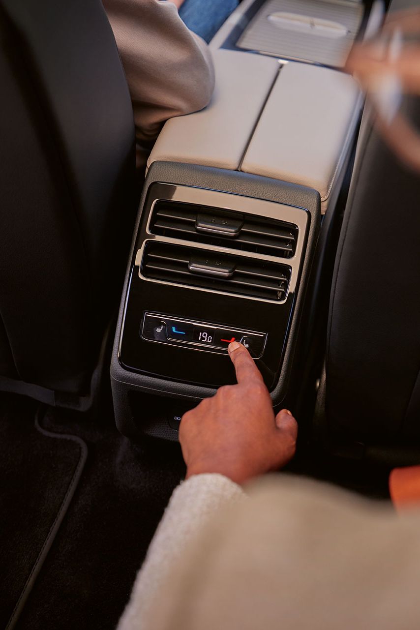 Eine Person sitzt auf dem Rücksitz im VW ID.7 und bedient die „Air Care Climatronic“ für die Rücksitze.