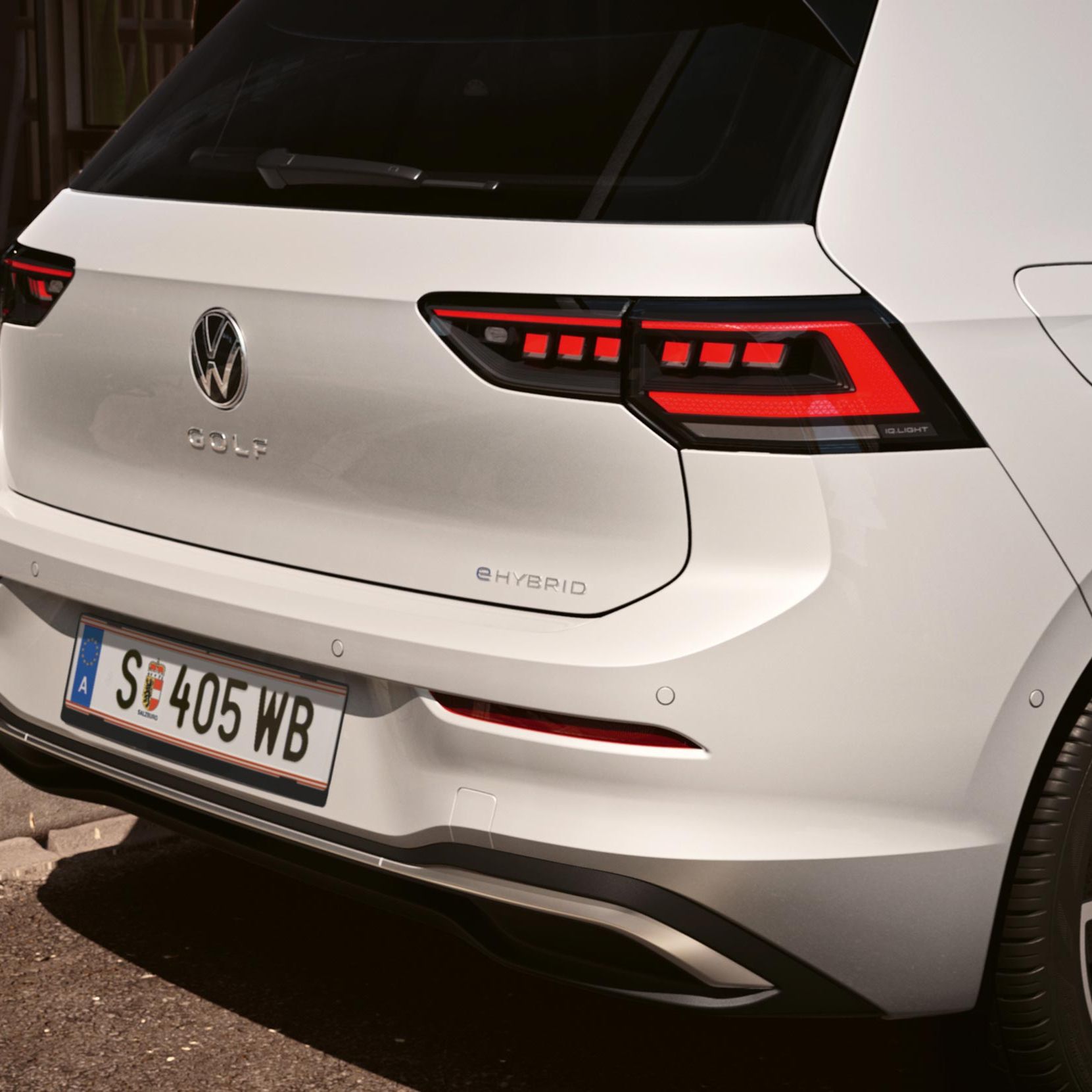 Heckansicht eines weißen VW Golf eHybrid mit LED-Rückleuchten.