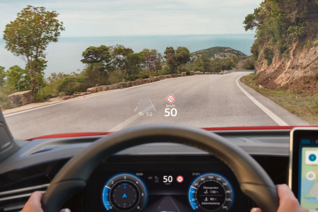 Fahreransicht im VW Tiguan mit Navigationshinweisen des Head-up-Displays auf der Frontscheibe.