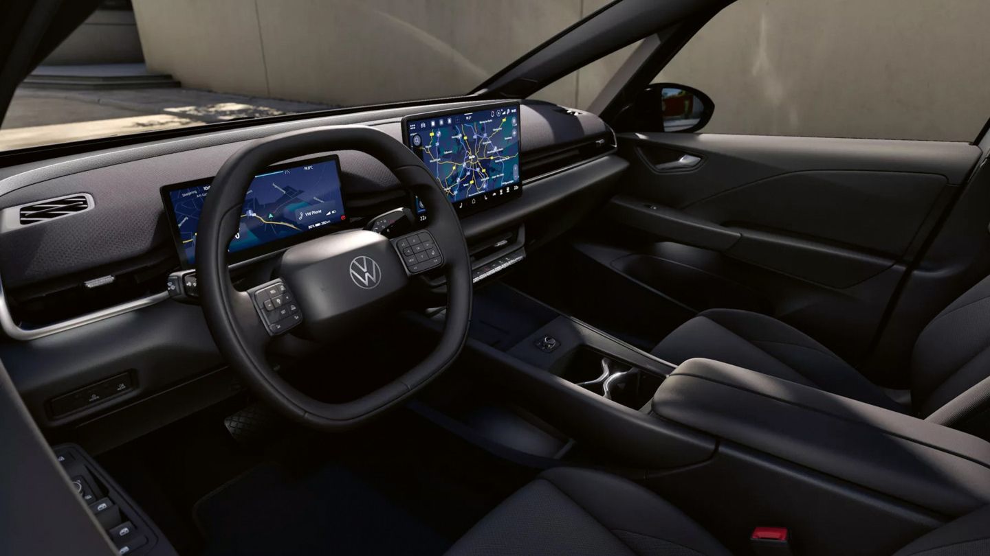 Modernes, dunkles Autointerieur mit digitalem Cockpit und großem zentralen Touchscreen, auf dem eine Navigationskarte zu sehen ist. Das Multifunktionslenkrad mit Markenlogo ist im Vordergrund, umgeben von schlanken Lüftungsdüsen und einer reduzierten Armaturenbrettgestaltung. Mittelkonsole mit Getränkehaltern und Schaltfläche, insgesamt ein aufgeräumtes, hochwertiges Design.