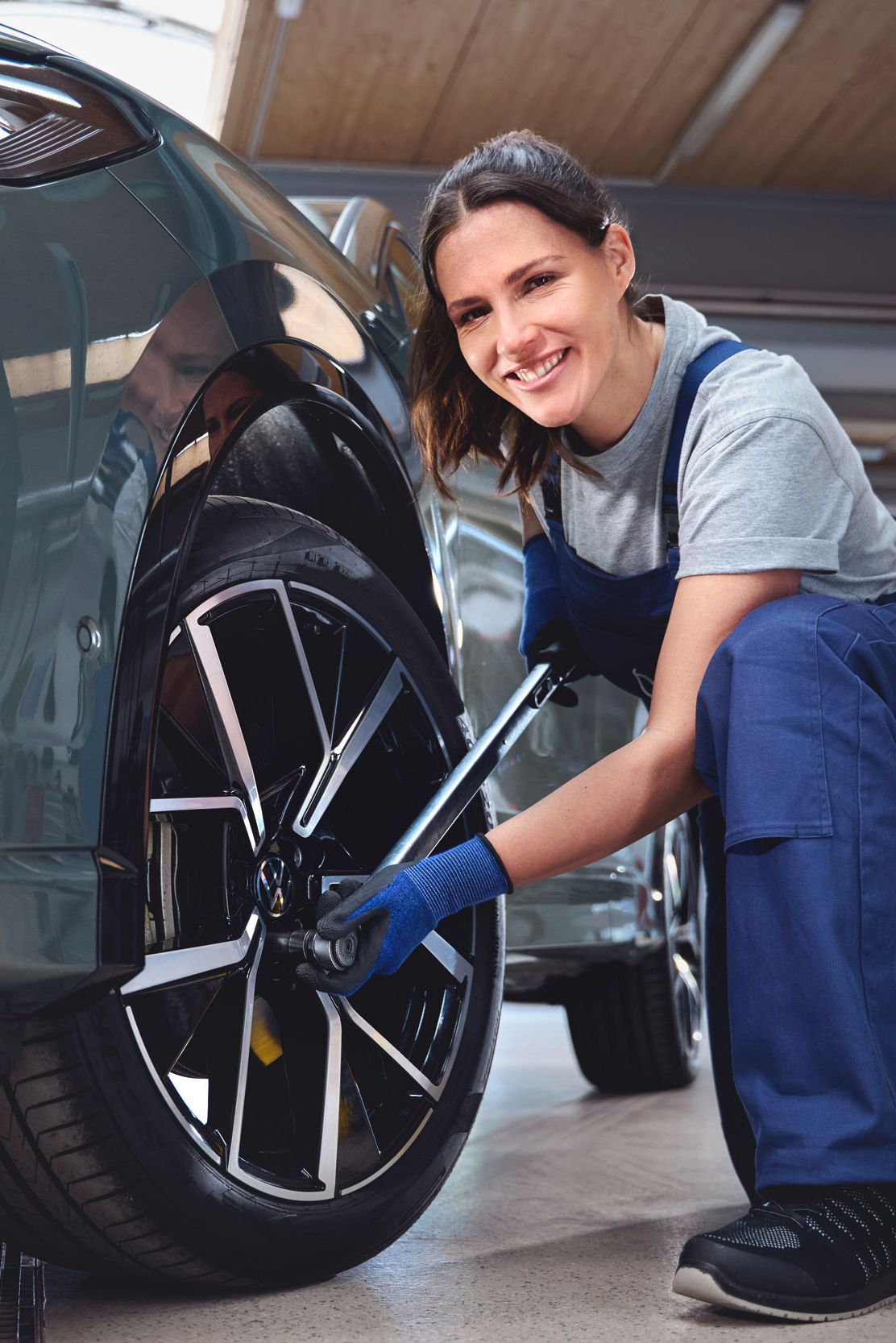 Eine Volkswagen Technikerin beim Reifenwechsel von einem Volkswagen Tiguan.