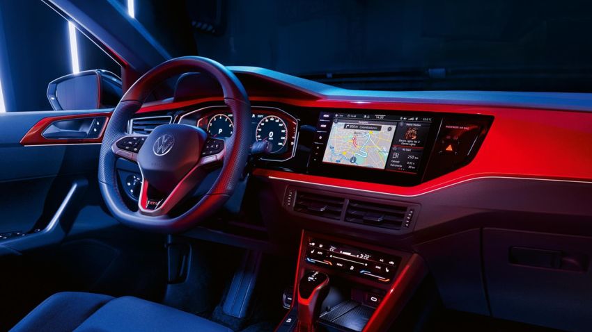 Innenraum eines weißen VW Polo GTI mit Blick vom Beifahrersitz auf Infotainment-Display mit Navigationskarte.