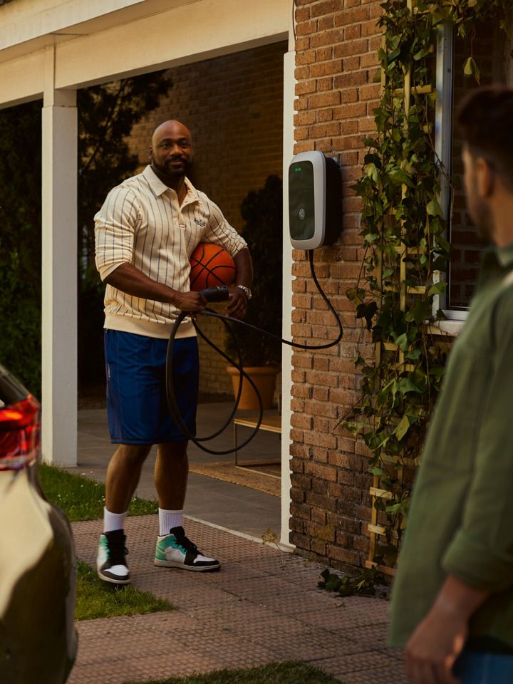 Ein Mann holt einen Ladestecker seiner Wallbox um seinen ID.3 zu laden. 