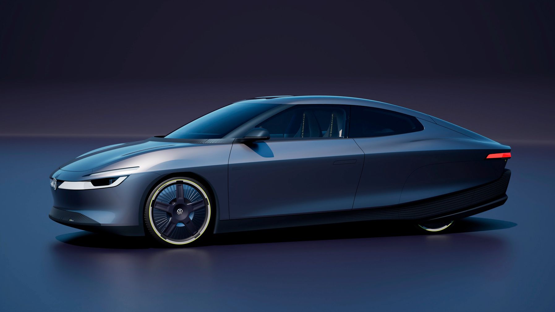 Futuristisches, dunkelgraues Elektroauto mit sehr glatter, aerodynamischer Karosserie und schmalen LED-Scheinwerfern, seitlich von links gezeigt. Die Felgen wirken wie geschlossene Scheibenräder, und das Fahrzeug steht in einer minimalistisch ausgeleuchteten, dunklen Studioumgebung.