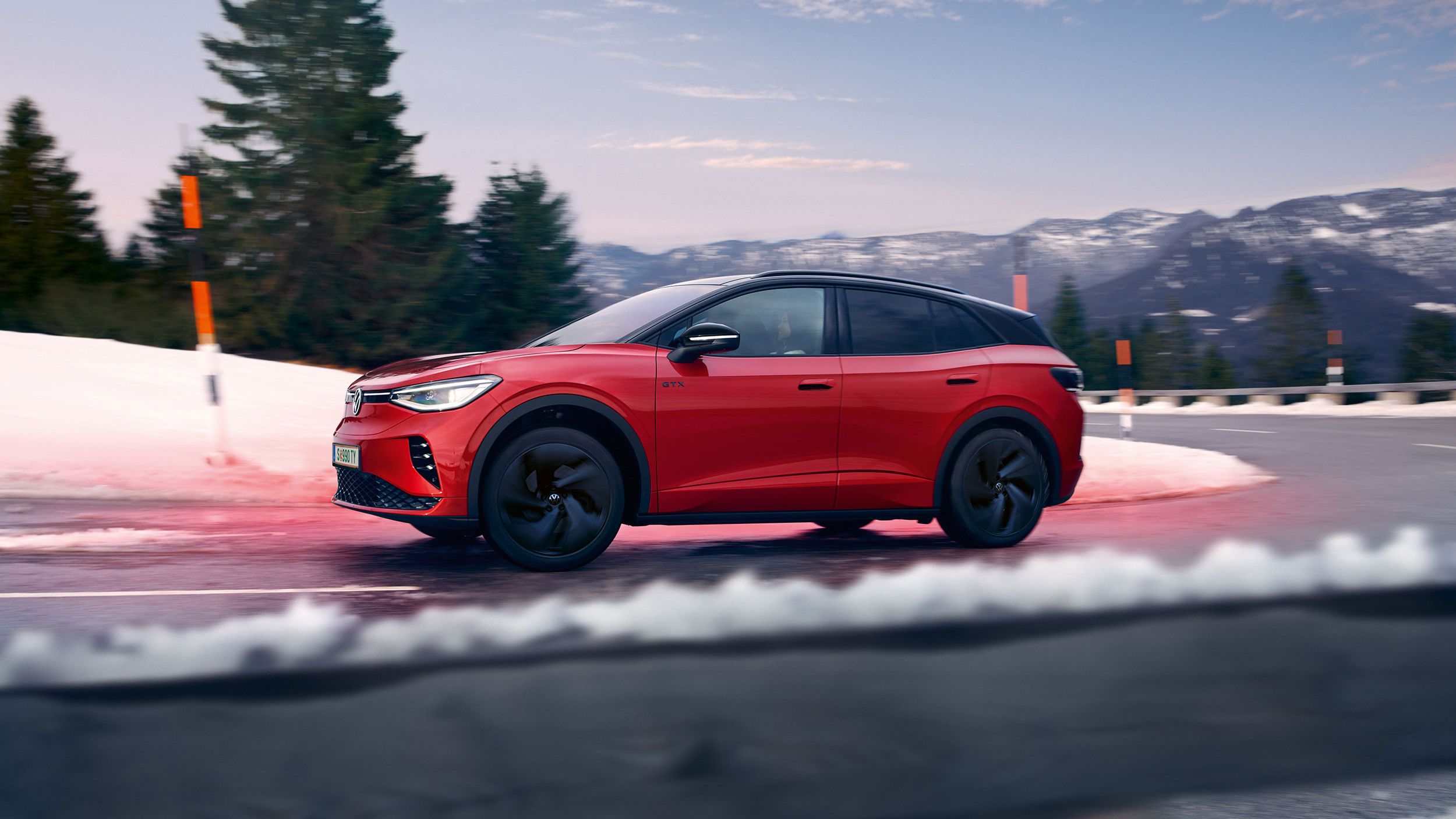 Roter VW ID.4 GTX fährt über einer Straße in Faistenau bei Salzburg 