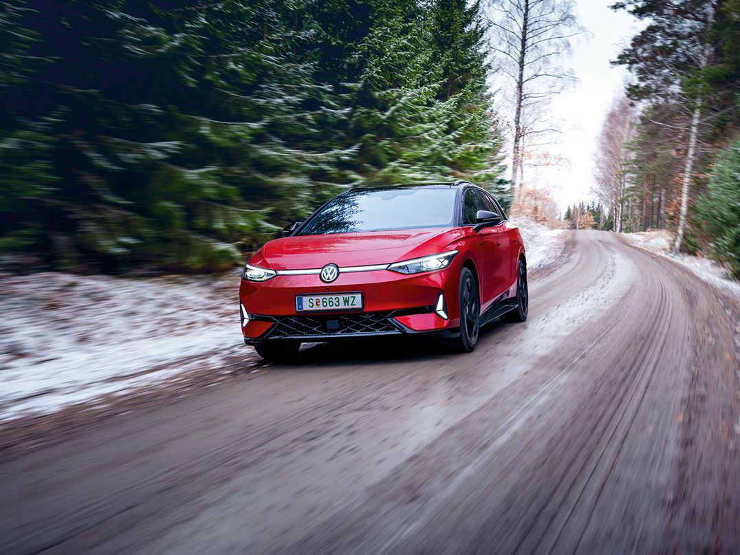 Ein roter VW ID.7 GTX fährt in Waldstraße im Winter