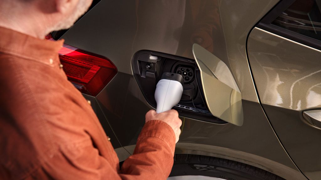 Ein Mann steckt den Ladestecker in die Ladebuchse des VW ID.3