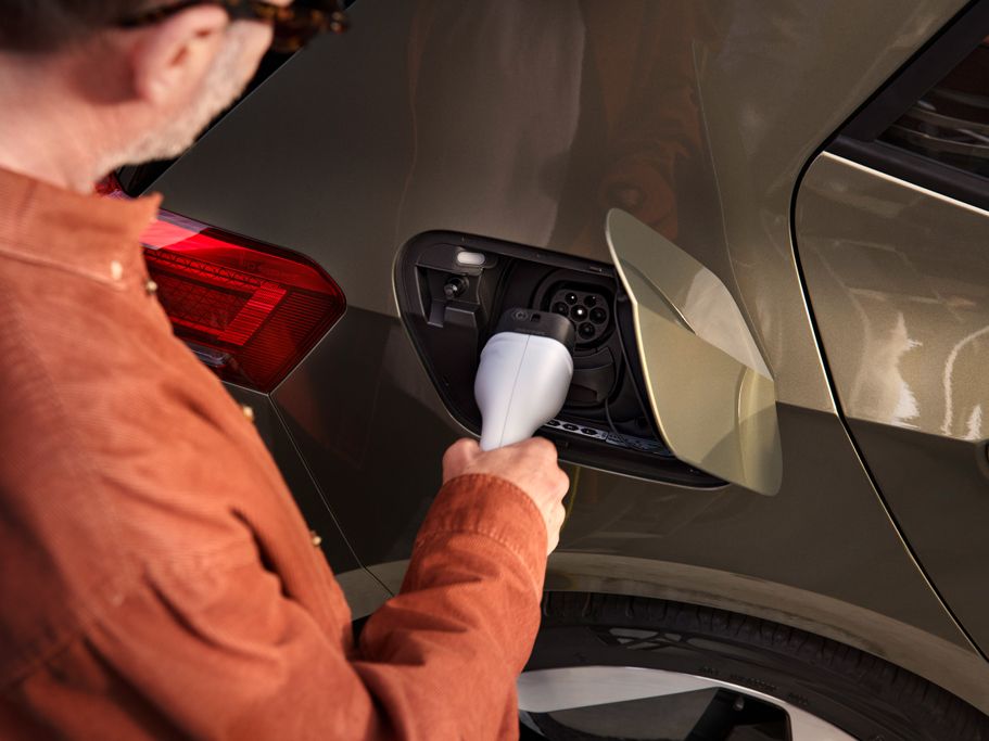 Ein Mann steckt den Ladestecker in die Ladebuchse des VW ID.3