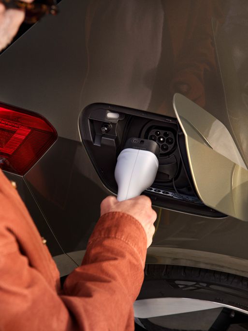 Ein Mann steckt den Ladestecker in die Ladebuchse des VW ID.3
